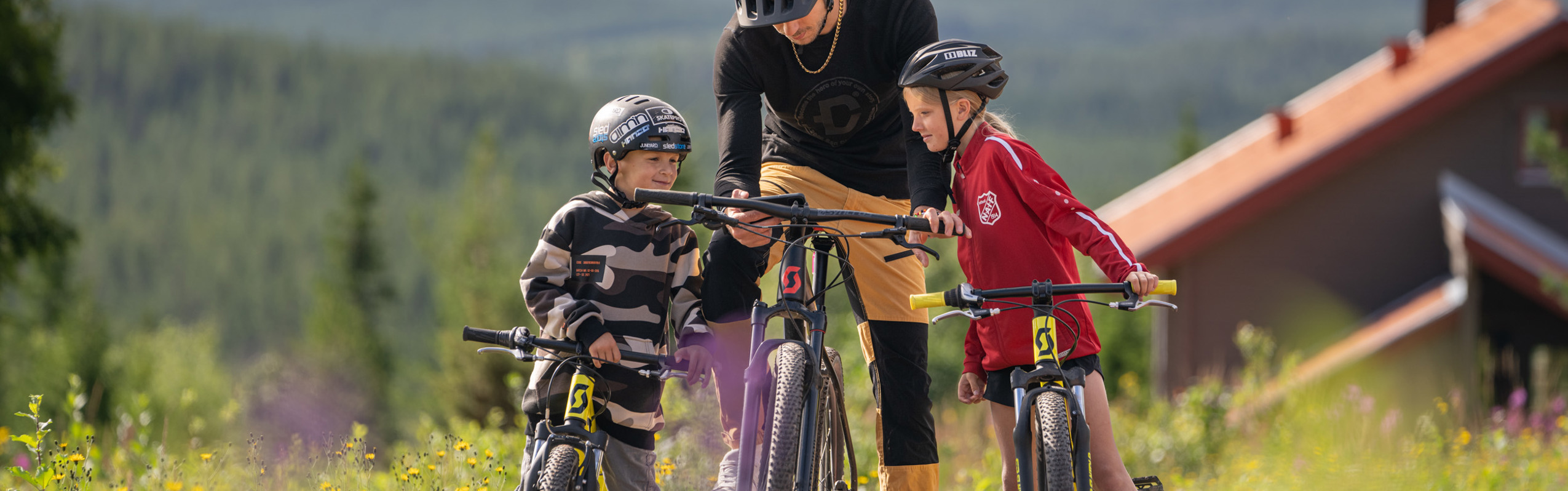 Familj cyklar MTB med vy över Orsasjön - upplevelserika turer i Orsa Grönklitt.