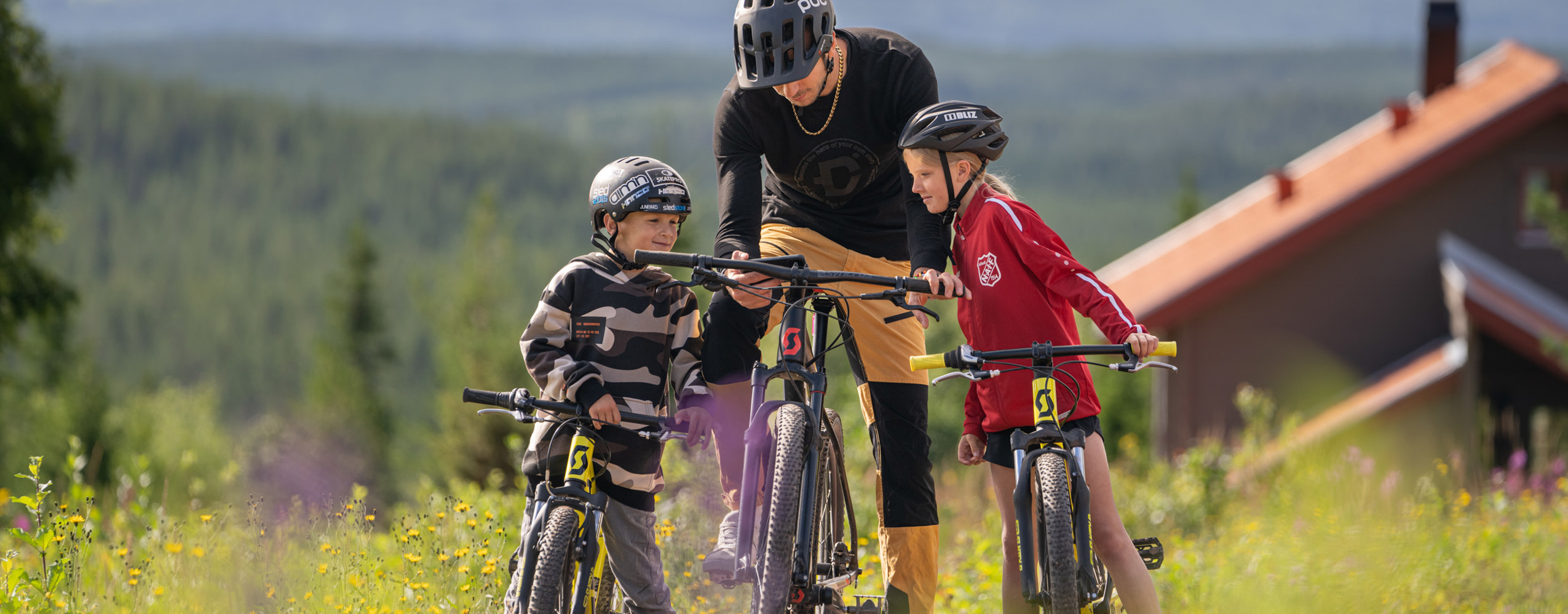 Familj cyklar MTB med vy över Orsasjön - upplevelserika turer i Orsa Grönklitt.