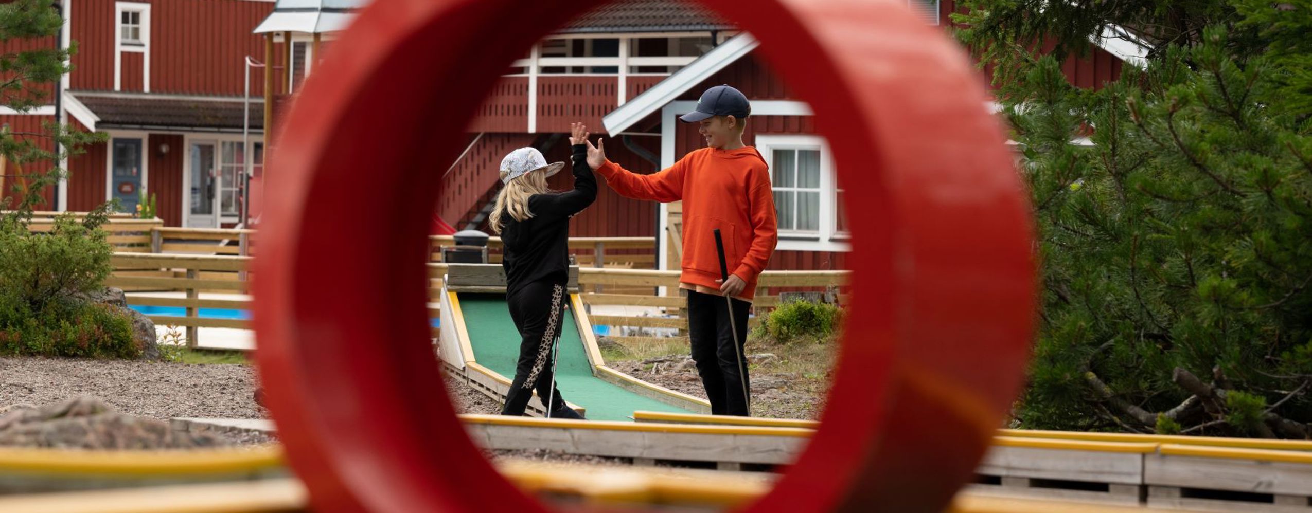 High five under minigolfspel - två barn leker glatt i Orsa Grönklitt.